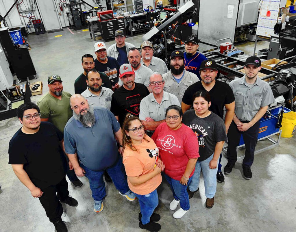 Picture of employees posing in a manufacturing shop.